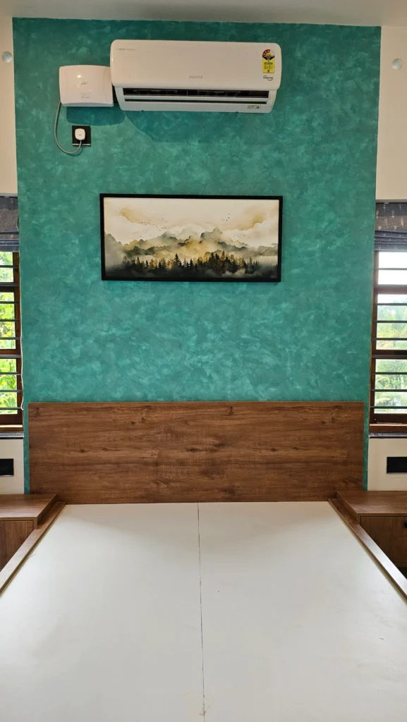 Bedroom with a teal textured wall, timber headboard panel and wall art