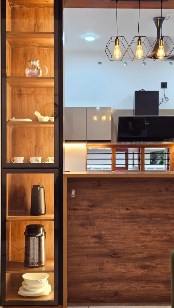 Timber display shelving next to a kitchen counter with glass pendant lights