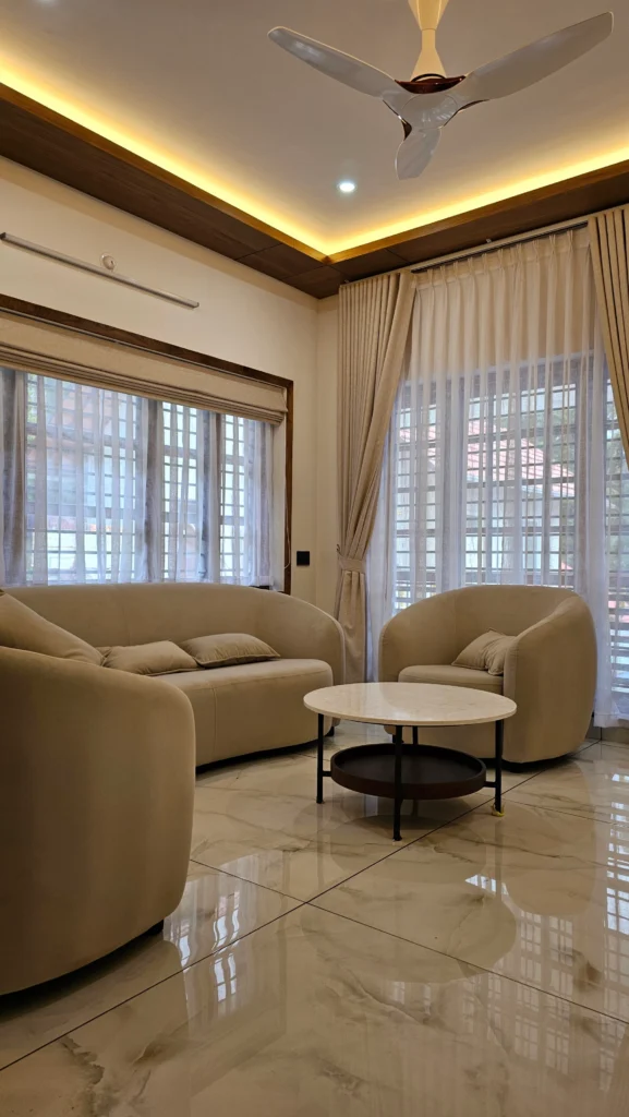 Living room with beige sofas, a round marble coffee table and a cove-lit ceiling