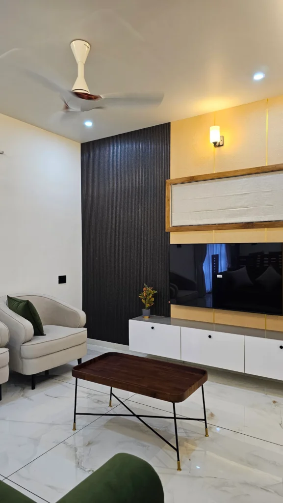 Living room with a fluted black wall panel, white TV unit and timber coffee table