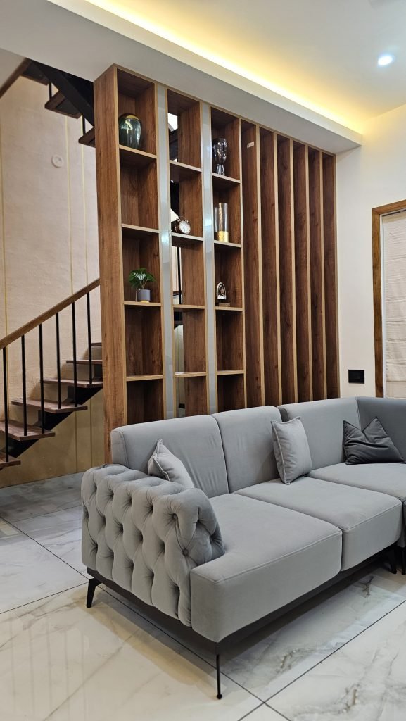 Light grey sofa beside a tall timber partition and staircase