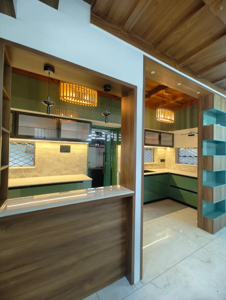 Kitchen with a timber breakfast counter, green cabinets and teal display shelves
