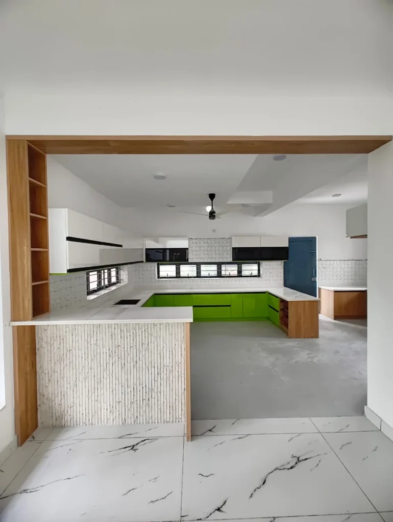 Open kitchen through an oak-framed opening, with lime green cabinets and a stone-clad counter, Trivandrum