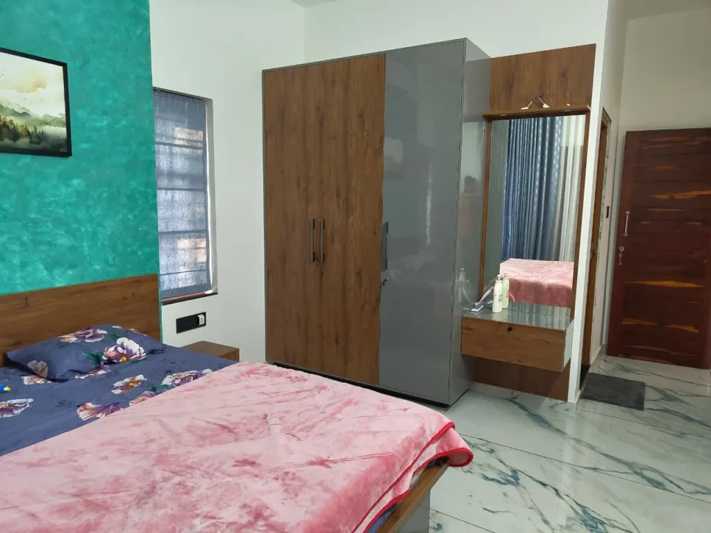 Bedroom with a teal textured wall, oak and grey wardrobe and a floating dresser