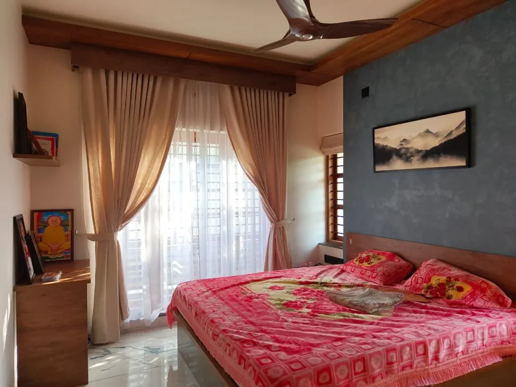 Bedroom with timber ceiling trim, sheer curtains and a blue feature wall