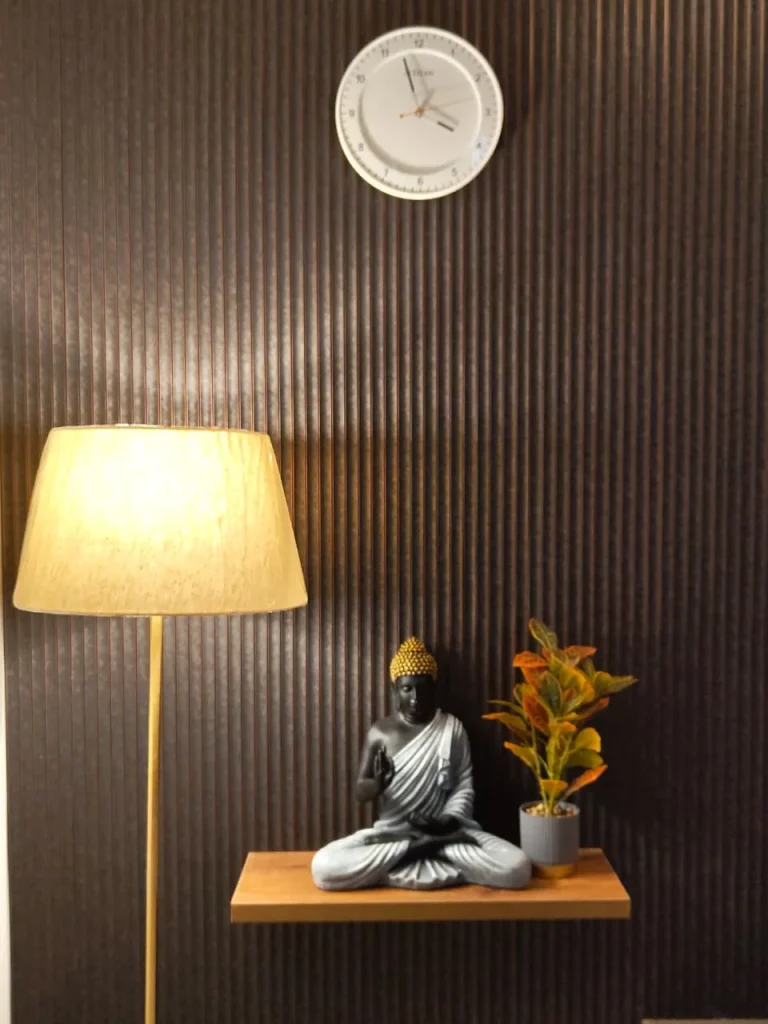 Buddha figure and plant on a floating oak shelf with fluted wall panelling