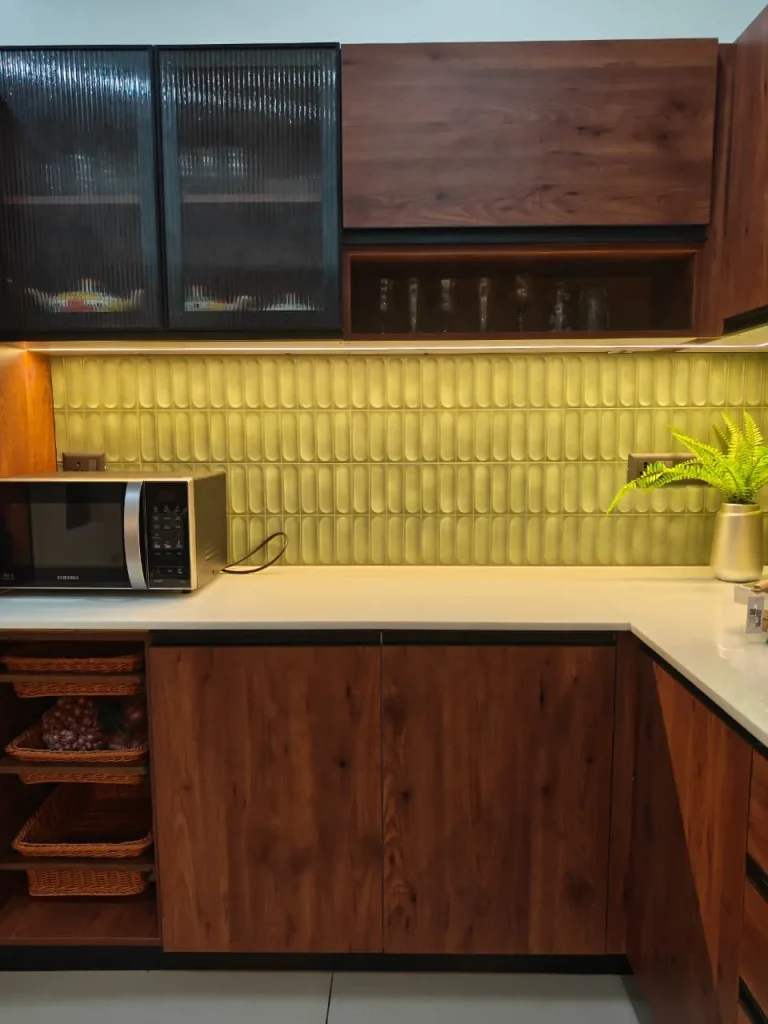 Fluted-glass wall cabinets, open glass shelf and wicker baskets in a walnut kitchen