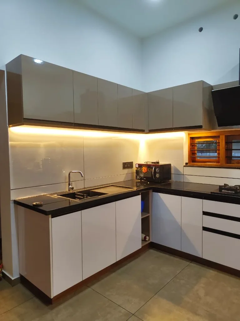 L-shaped white kitchen with high-gloss taupe wall cabinets and under-cabinet lighting