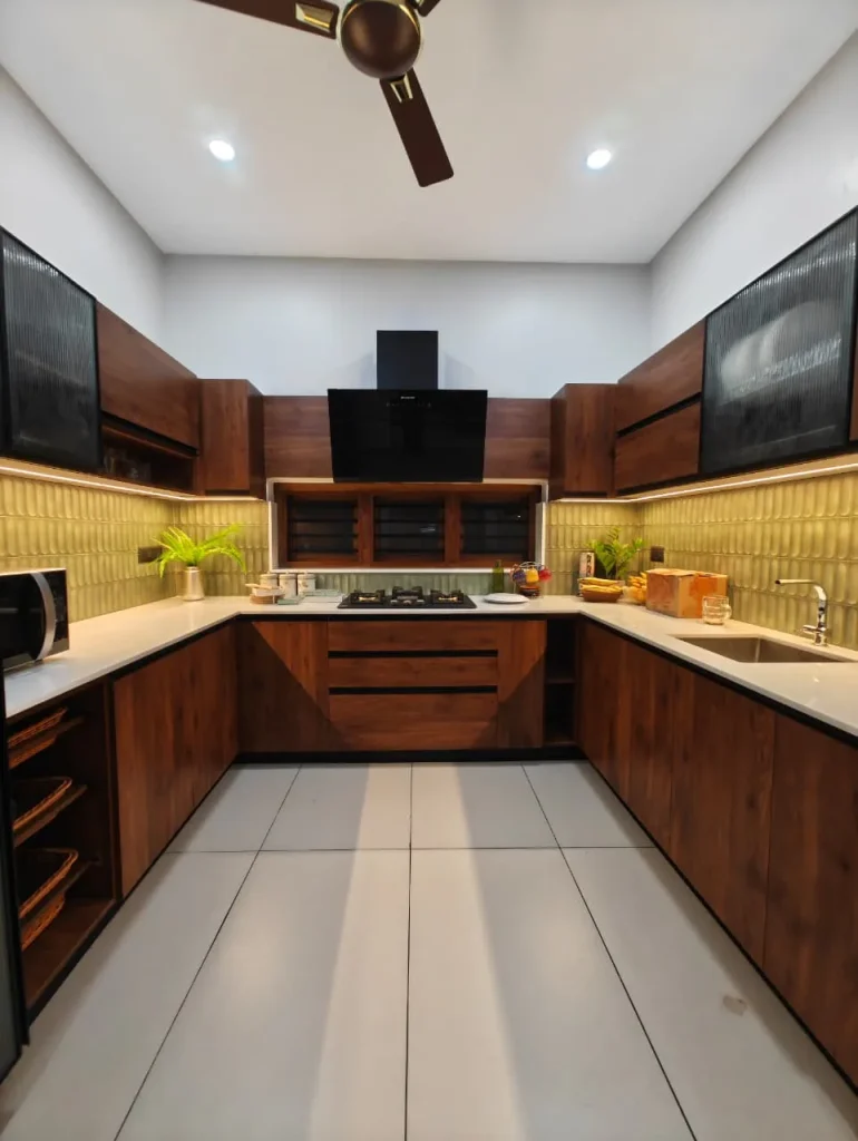 U-shaped walnut kitchen with fluted-glass wall cabinets and a sage tiled backsplash