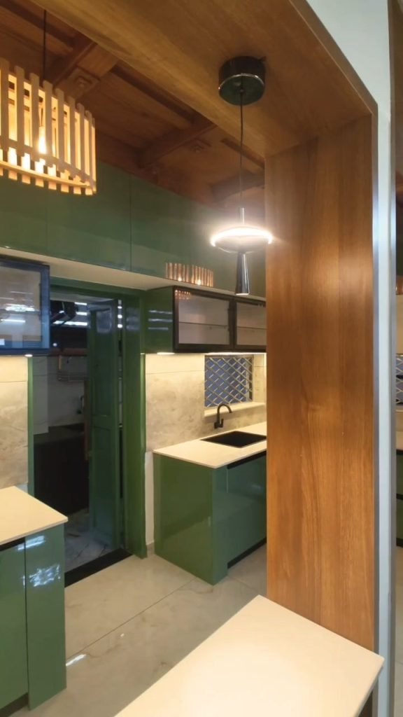 Kitchen with green cabinets seen through a timber frame